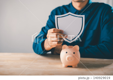 Man holds shield over piggy bank to protect money, save and plan, financial finance insurance saving ensures security, long term capital investment and sustainable wealth growth Man holds shield over piggy bank to protect money, save and plan, financial finance insurance saving ensures security, long term capital investment and sustainable wealth growth 140929019