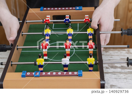 Hands holding a mini foosball table Hands holding a mini foosball table 140929736
