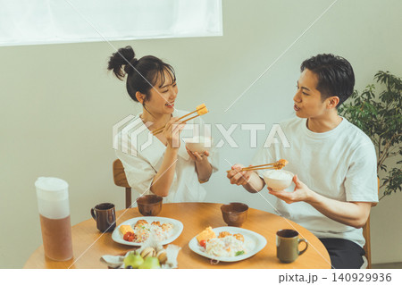 向き合って会話を楽しみながら食事するカップル 140929936