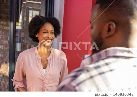African american friends chatting on urban sidewalk at storefront entrance with accent wall 140930345