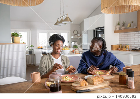 African american couple sharing breakfast at kitchen table with scrambled eggs and press coffee African american couple sharing breakfast at kitchen table with scrambled eggs and press coffee 140930392