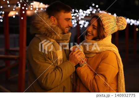 Happy couple spending time at Christmas fair Happy couple spending time at Christmas fair 140932775
