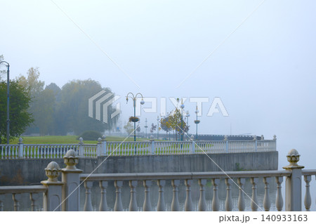 Misty autumn morning along a classic marble waterfront promenade with ornate lamps Misty autumn morning along a classic marble waterfront promenade with ornate lamps 140933163