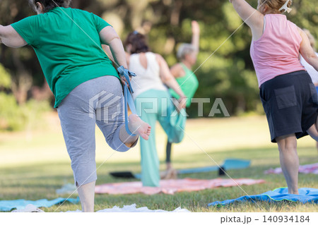 Mature women doing yoga stretching outdoor in park Mature women doing yoga stretching outdoor in park 140934184
