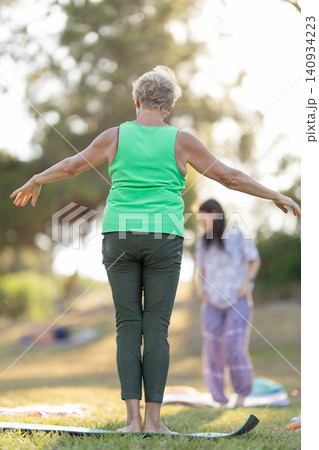 Senior woman practicing yoga outdoors in a park Senior woman practicing yoga outdoors in a park 140934223