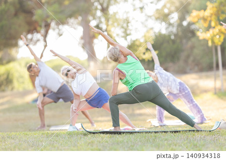 Seniors practicing yoga for health and wellness outdoors Seniors practicing yoga for health and wellness outdoors 140934318