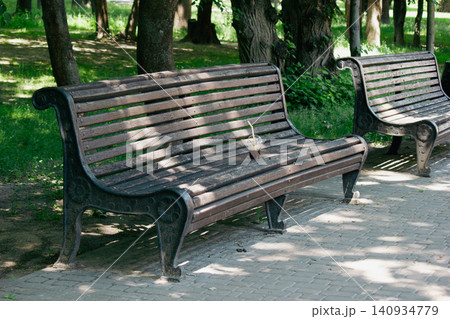 Disposable plastic cup left on empty wooden bench in public park Disposable plastic cup left on empty wooden bench in public park 140934779