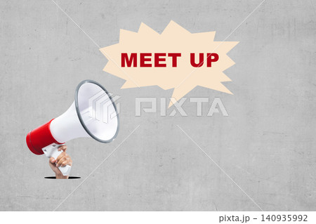 Hand holding a megaphone next to a speech bubble with 'Meet Up' text against a textured concrete background 140935992