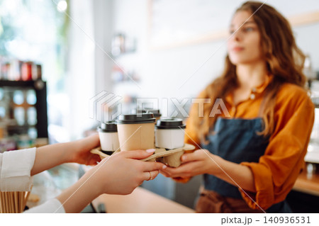 The coffee shop owner gives orders to go. Takeaway drinks concept, small business. 140936531