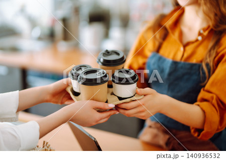 The coffee shop owner gives orders to go. Takeaway drinks concept, small business. 140936532