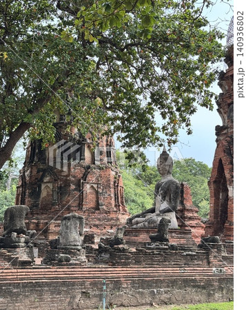 Historic Seated Buddha Image Surrounded By Crumbled Stone Pillars. Historic Seated Buddha Image Surrounded By Crumbled Stone Pillars. 140936802