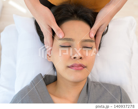 Young woman enjoying face massage in spa salon Young woman enjoying face massage in spa salon 140937278