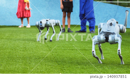 Robot dog companions interacting with people on green artificial grass Robot dog companions interacting with people on green artificial grass 140937851