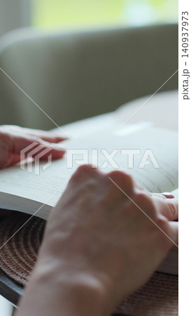 Vertical video Close-up unrecognizable woman reading a book. Vertical video Close-up unrecognizable woman reading a book. 140937973