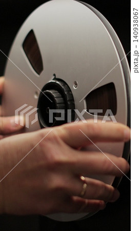 Vertical video Man puts bobbins with tape onto a recorder. Bobbin tape recorder. Old vintage reel-to-reel player. Vintage tape recorder roller. Vertical video Man puts bobbins with tape onto a recorder. Bobbin tape recorder. Old vintage reel-to-reel player. Vintage tape recorder roller. 140938067