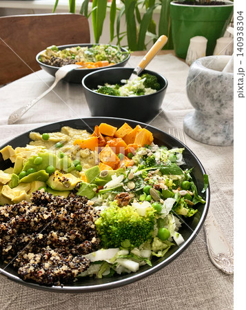 A bowl filled with quinoa, roasted pumpkin, hummus, and a salad of fresh avocado is ready to eat. This meal is gluten free and offers a healthy start to the day A bowl filled with quinoa, roasted pumpkin, hummus, and a salad of fresh avocado is ready to eat. This meal is gluten free and offers a healthy start to the day 140938304