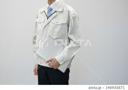 ノートパソコンを持つ作業服の若い男性 ノートパソコンを持つ作業服の若い男性 140938871