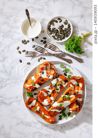 Baked butternut squash halves with yogurt sauce Baked butternut squash halves with yogurt sauce 140939093