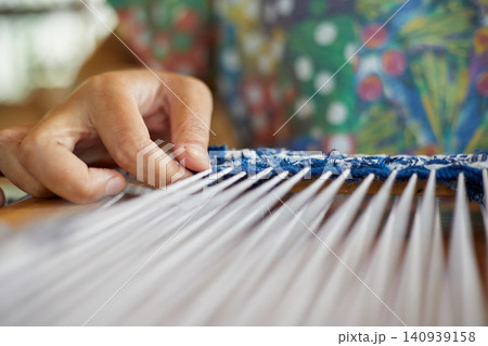 Weaving on a loom frame Weaving on a loom frame 140939158
