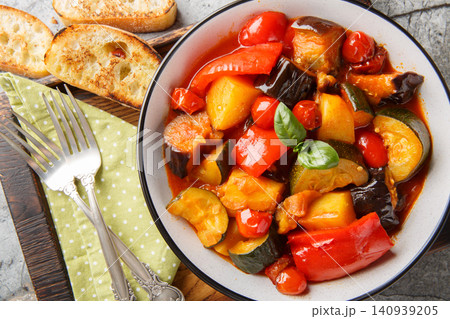 Ciambotta Italian vegetable stew with potatoes, eggplants, tomatoes and peppers closeup on the plate. Horizontal top view Ciambotta Italian vegetable stew with potatoes, eggplants, tomatoes and peppers closeup on the plate. Horizontal top view 140939205