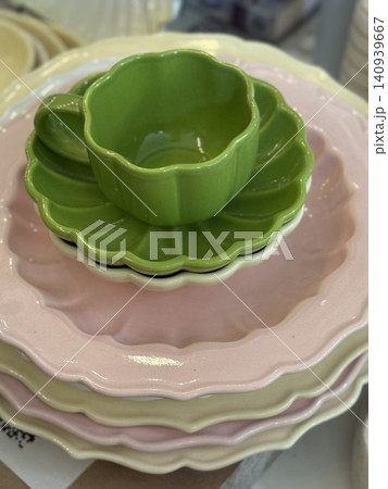 Stacked ceramic tableware in pastel colors with green teacup as centerpiece Stacked ceramic tableware in pastel colors with green teacup as centerpiece 140939667