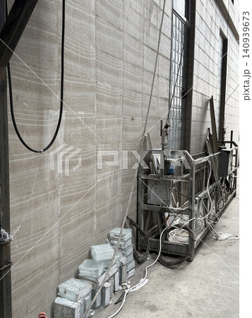 Industrial warehouse interior with metal structures and cables creates an unfinished, raw atmosphere Industrial warehouse interior with metal structures and cables creates an unfinished, raw atmosphere 140939673