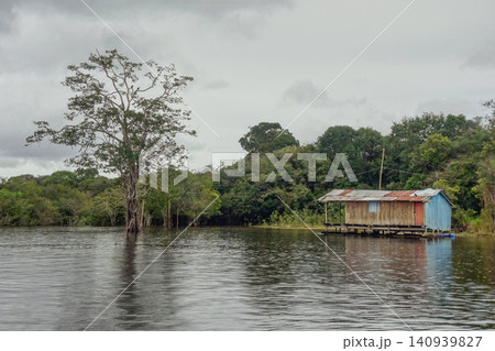 Floating wooden houses of riverside dwellers on banks of tropical river. nearby Manaus, Brazil Floating wooden houses of riverside dwellers on banks of tropical river. nearby Manaus, Brazil 140939827