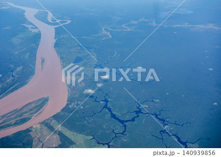 Aerial view over immense Amazon rainforest with a muddy river cutting through forest. Amazonas, Brazil Aerial view over immense Amazon rainforest with a muddy river cutting through forest. Amazonas, Brazil 140939856