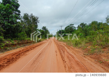 dirt and mud road cuts through Amazon rainforest in Brazil dirt and mud road cuts through Amazon rainforest in Brazil 140939880