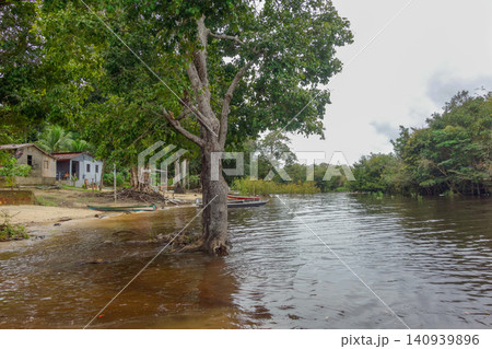 flooded riverbanks of amazon rainforest with riverside wooden houses, nearby Manaus, Brazil flooded riverbanks of amazon rainforest with riverside wooden houses, nearby Manaus, Brazil 140939896