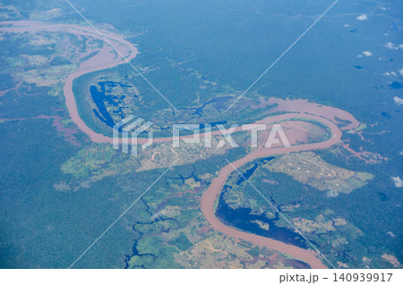 Aerial view over immense Amazon rainforest with a muddy river cutting through forest. Amazonas, Brazil Aerial view over immense Amazon rainforest with a muddy river cutting through forest. Amazonas, Brazil 140939917