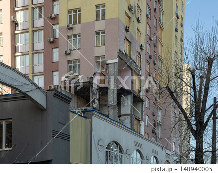 Damaged apartment building facade showing structural destruction from a blast, highlighting the impact of urban warfare on civilian infrastructure and human living in crisis zones Damaged apartment building facade showing structural destruction from a blast, highlighting the impact of urban warfare on civilian infrastructure and human living in crisis zones 140940005