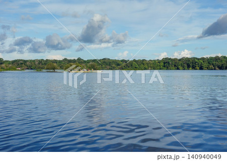 canoe with tourists sails on river that cuts through Amazon rainforest in Brazil canoe with tourists sails on river that cuts through Amazon rainforest in Brazil 140940049