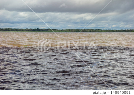 bands of water with different colorations in junction of Negro river and Amazonas river. Manaus, Brazil bands of water with different colorations in junction of Negro river and Amazonas river. Manaus, Brazil 140940091