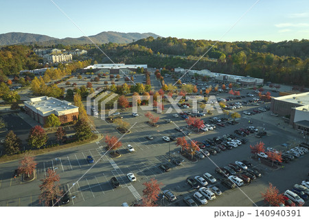 View from above of american grocery store with many parked cars on parking lot with lines and markings for parking places and directions. Place for vehicles in front of a strip mall center View from above of american grocery store with many parked cars on parking lot with lines and markings for parking places and directions. Place for vehicles in front of a strip mall center 140940391