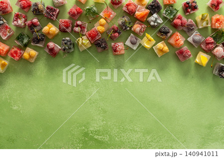Ice cubes with frozen berries and fruits and mint on a green background Ice cubes with frozen berries and fruits and mint on a green background 140941011