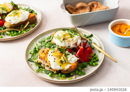 This meal features gluten free bread sandwiches topped with zucchini caviar and poached egg. It includes roasted red peppers and green peas, served with baked pears This meal features gluten free bread sandwiches topped with zucchini caviar and poached egg. It includes roasted red peppers and green peas, served with baked pears 140941026
