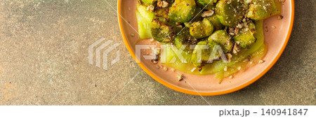 Baked Brussels sprouts are combined with zucchini slices and walnuts. The dish is served on a plate, ready for breakfast or lunch at home, banner Baked Brussels sprouts are combined with zucchini slices and walnuts. The dish is served on a plate, ready for breakfast or lunch at home, banner 140941847