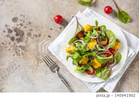 Summer fresh vegetable salad with crispy breaded feta cheese on a textured stonesurface. Tasty appetizer ready to eat. Top view flat lay background. Copy space. Summer fresh vegetable salad with crispy breaded feta cheese on a textured stonesurface. Tasty appetizer ready to eat. Top view flat lay background. Copy space. 140941902