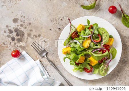Summer fresh vegetable salad with crispy breaded feta cheese on a textured stonesurface. Tasty appetizer ready to eat. Top view flat lay background. Summer fresh vegetable salad with crispy breaded feta cheese on a textured stonesurface. Tasty appetizer ready to eat. Top view flat lay background. 140941903