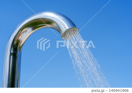 Outdoor pool shower with water stream against blue sky Outdoor pool shower with water stream against blue sky 140941906