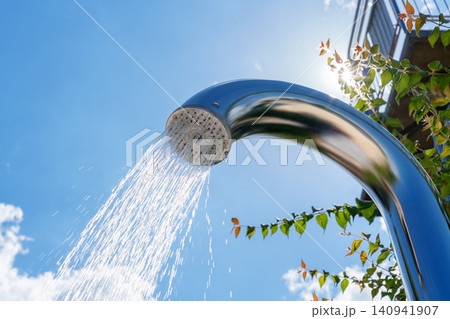 Outdoor pool shower with water stream against blue sky 140941907