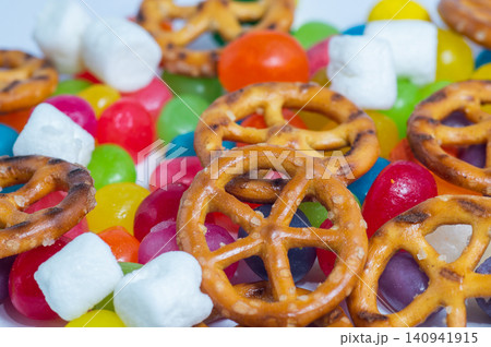 UTZ Classic Pretzel Wheels colorful candies, and marshmallows on a white background. Close-up. UTZ Classic Pretzel Wheels colorful candies, and marshmallows on a white background. Close-up. 140941915