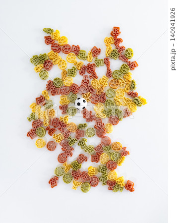 Shape of Germany arranged with colorful pasta pieces and a small soccer ball, forming a playful tribute to the football culture. 140941926