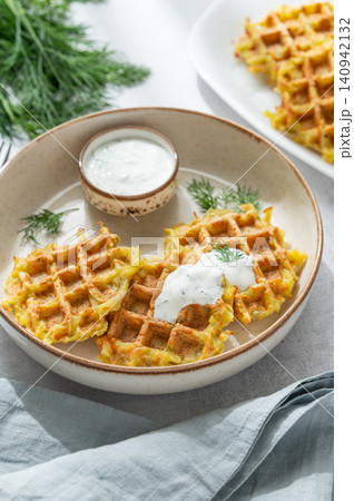 Vegetarian potato waffles with natural yogurt and dill on a plate on a light background Vegetarian potato waffles with natural yogurt and dill on a plate on a light background 140942132