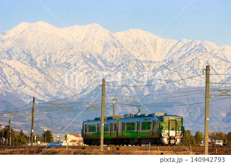 夕暮れの立山連峰を背景に富山市内を走行するあいの風とやま鉄道521系電車 夕暮れの立山連峰を背景に富山市内を走行するあいの風とやま鉄道521系電車 140942793