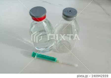 Two glass medical bottles of table salt and syringe. High quality photo 140942939