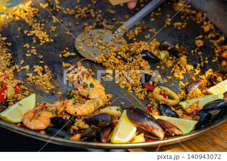 Seafood spanish paella with prawns mussels, saffron rice and lemon, spoon. Spanish cuisine, catering, restaurant menu, market food, street dining, Mediterranean cooking Seafood spanish paella with prawns mussels, saffron rice and lemon, spoon. Spanish cuisine, catering, restaurant menu, market food, street dining, Mediterranean cooking 140943072