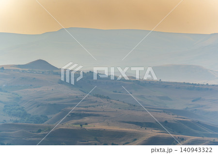 Layers of green mountains and hills in the haze during sunset. Panoramic View of Green hills and Meadow. 140943322