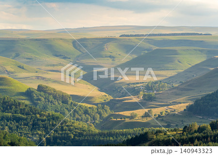 Layers of green mountains and hills in the haze during sunset. Panoramic View of Green hills and Meadow. 140943323